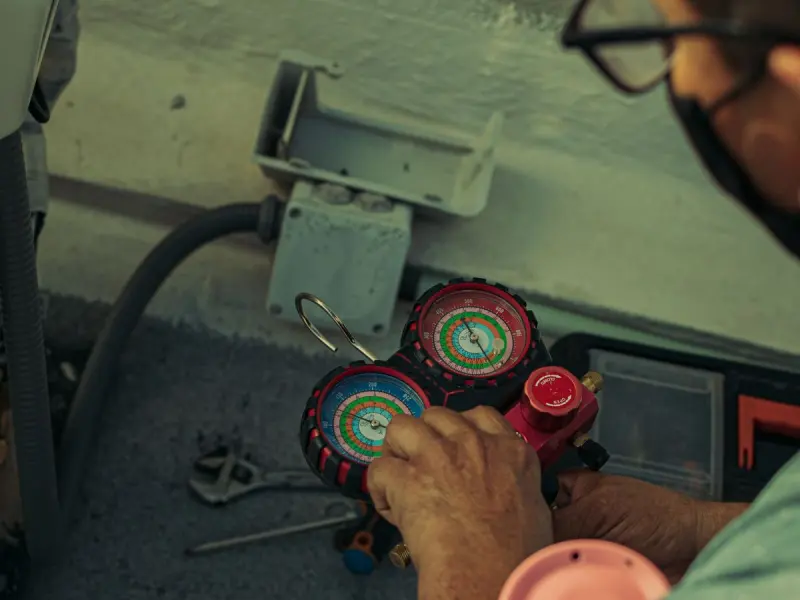 Technician charging a new air conditioning system using refrigerant manifold gauges