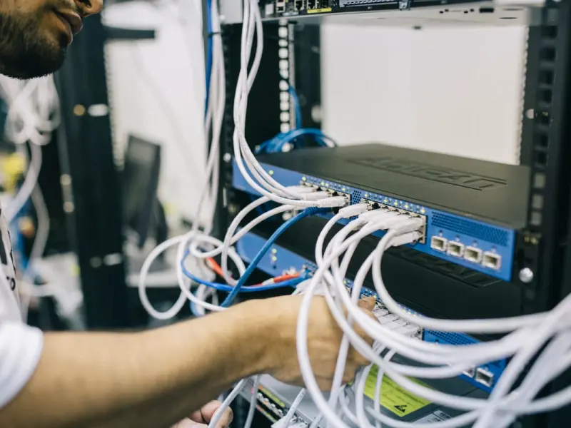 IT professional configuring network cables and switches