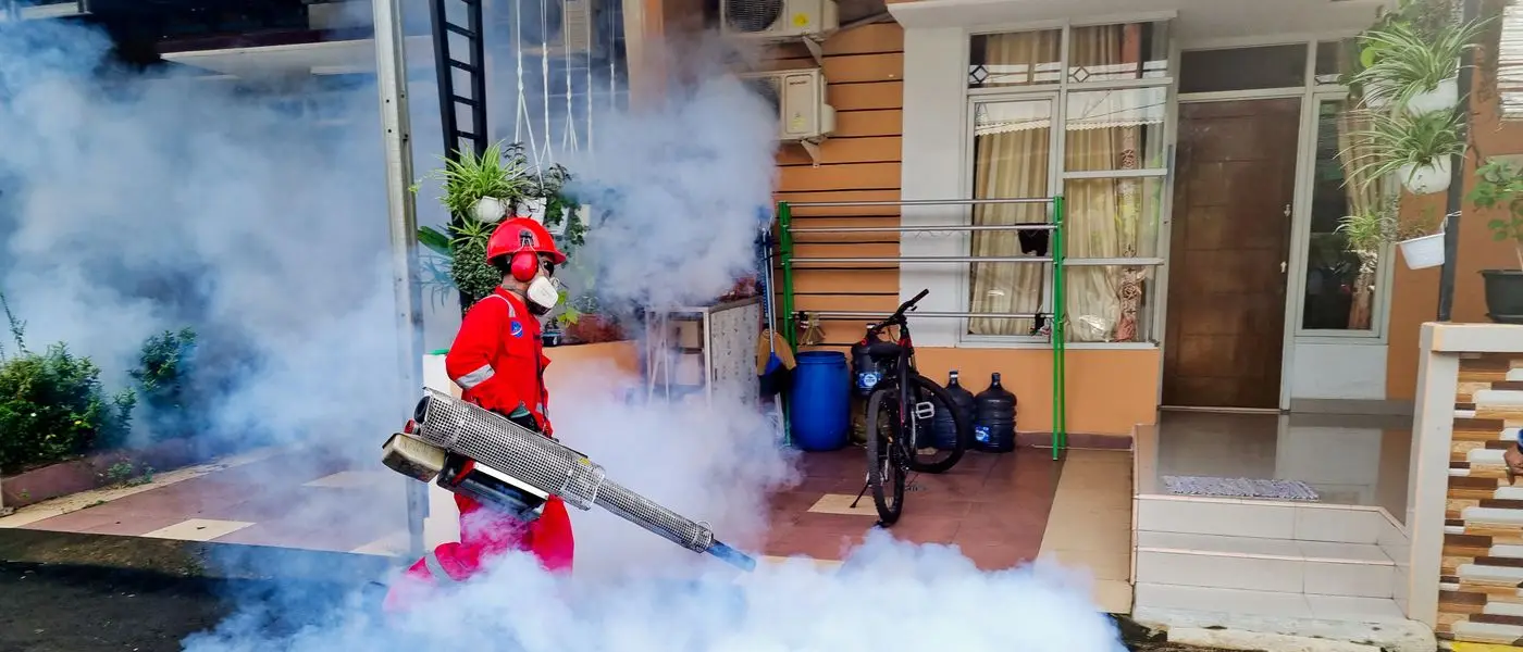 Pest control specialist treating a property exterior