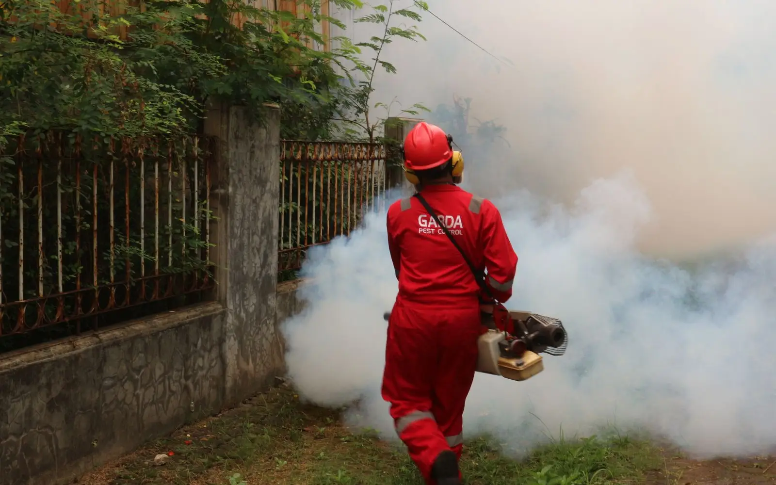 Sentry pest control technician fogging a residential yard for mosquito treatment