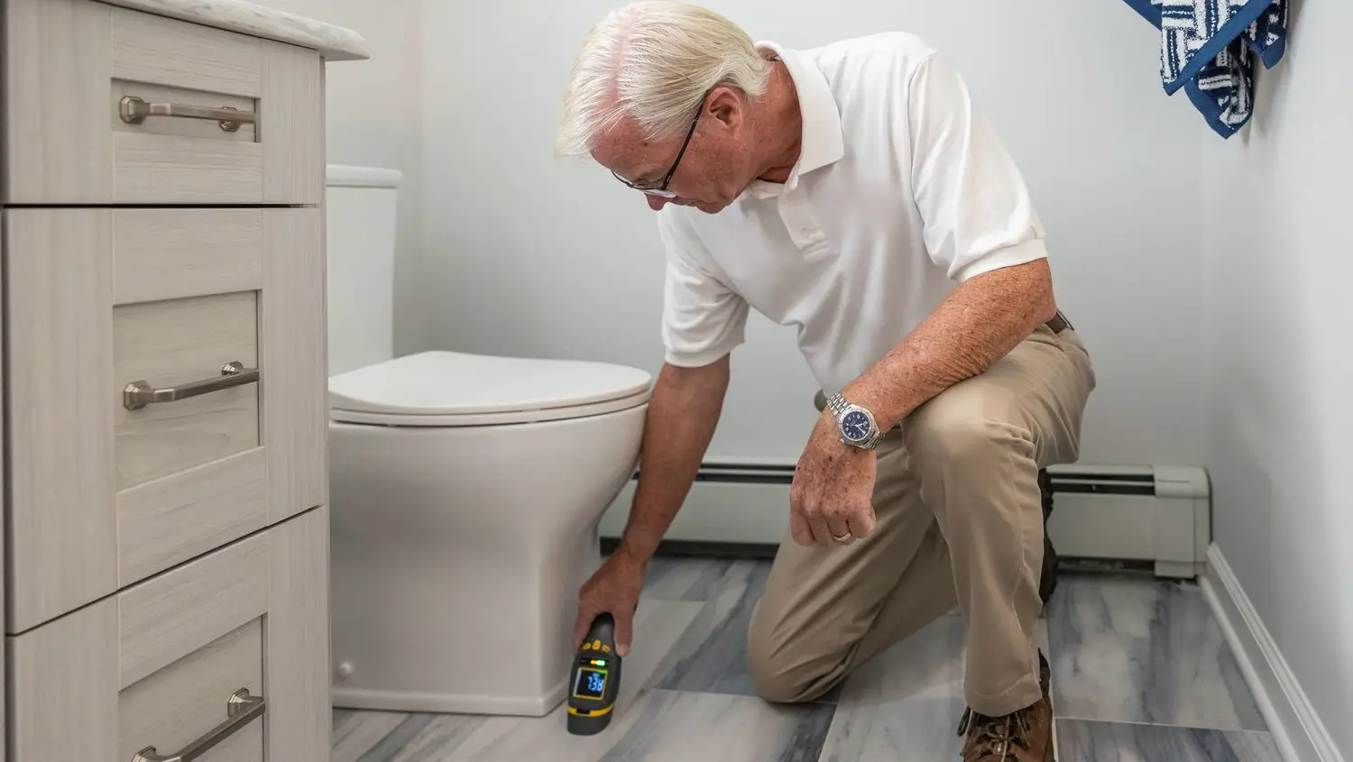 Copperline plumber inspecting a bathroom toilet and supply line during a service call