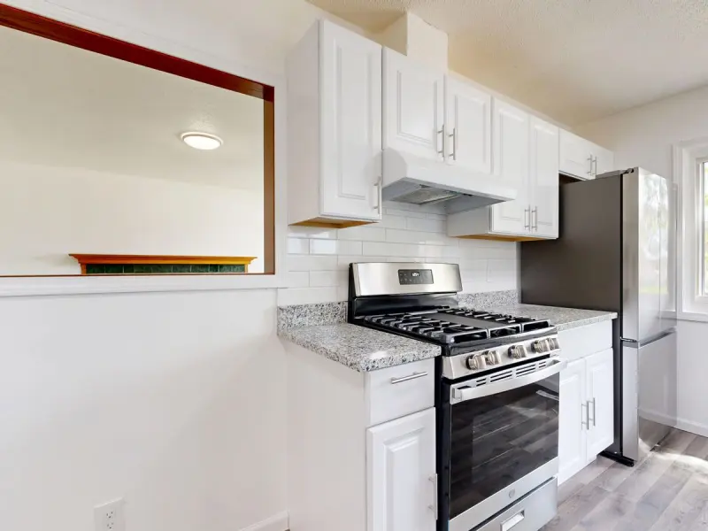 Renovated kitchen with white cabinetry and stainless steel appliances