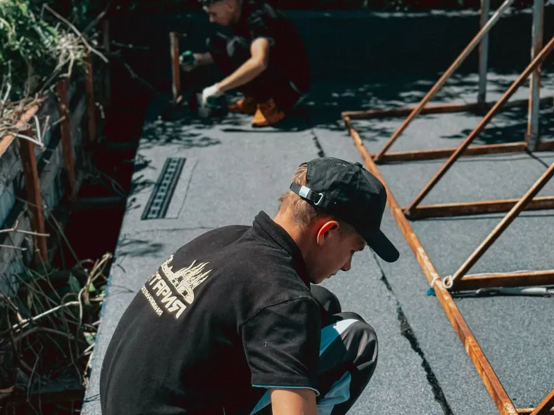 Contractor installing waterproofing membrane on a flat commercial roof