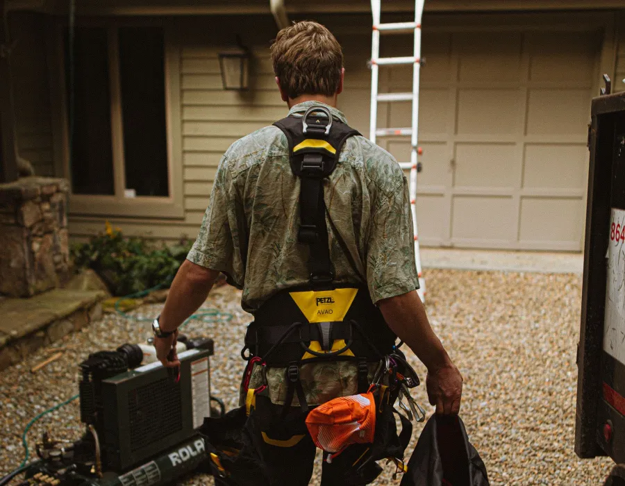 Summit Ridge roofing foreman in safety harness arriving at a residential job site