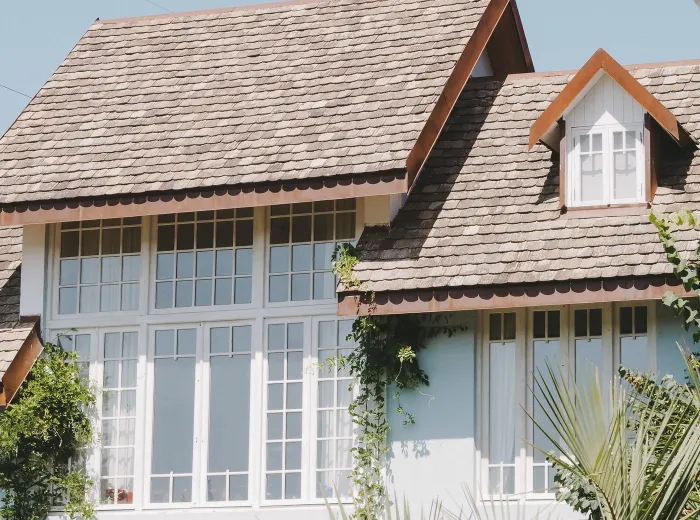 Completed shingle roof on a large suburban home with dormer windows